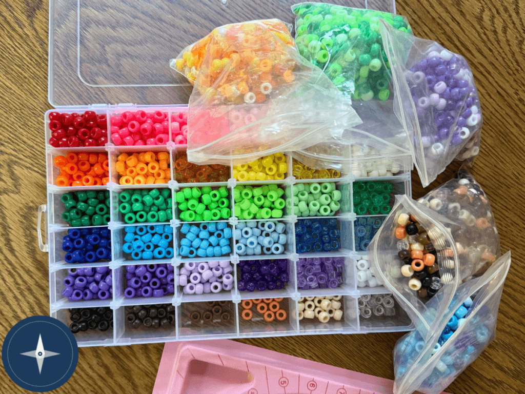 Bead crafts for kids organized by color in a clear bead organizer