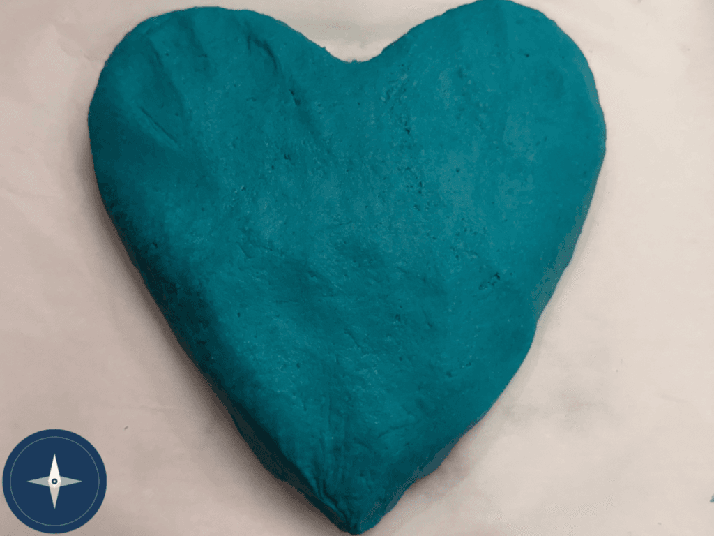 Teal heart-shaped no-cook play dough on a countertop
