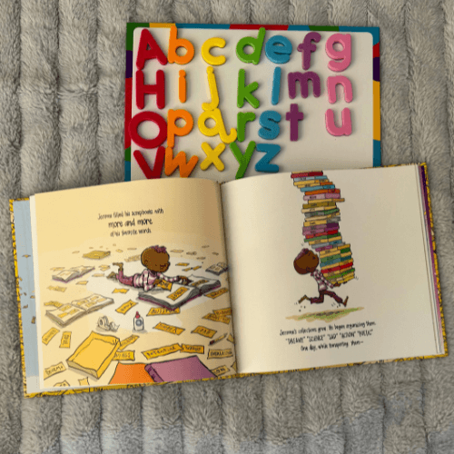 Open copy of The Word Collector by Peter H. Reynolds next to colorful magnetic alphabet letters